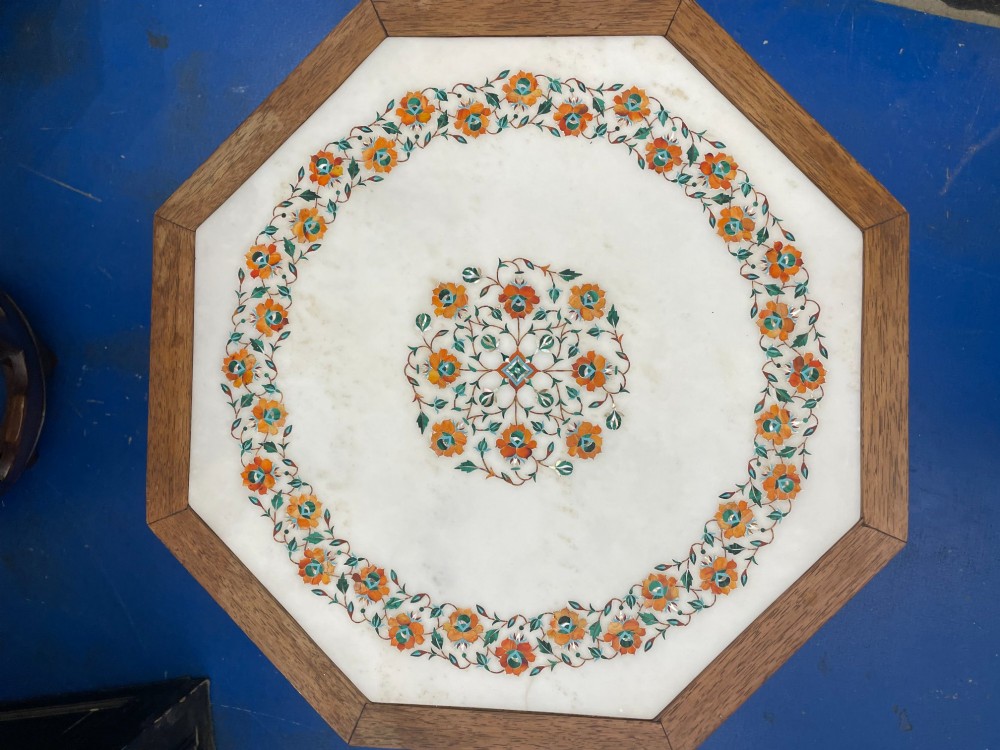An octagonal wooden side table featuring a white marble top with floral stone inlay and a pierced carved wooden base. View II