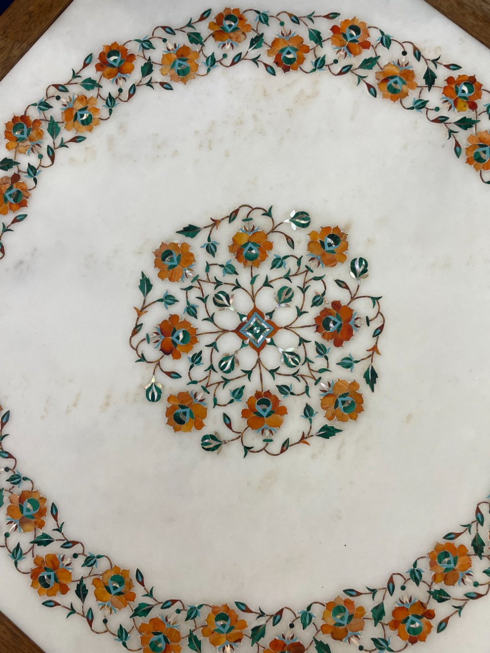 An octagonal wooden side table featuring a white marble top with floral stone inlay and a pierced carved wooden base. View VI