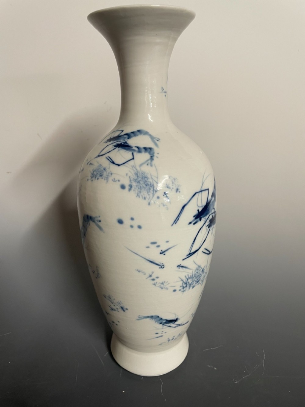 A tall white porcelain vase with a flared rim, featuring hand-painted cobalt blue shrimp motifs around the body. View III