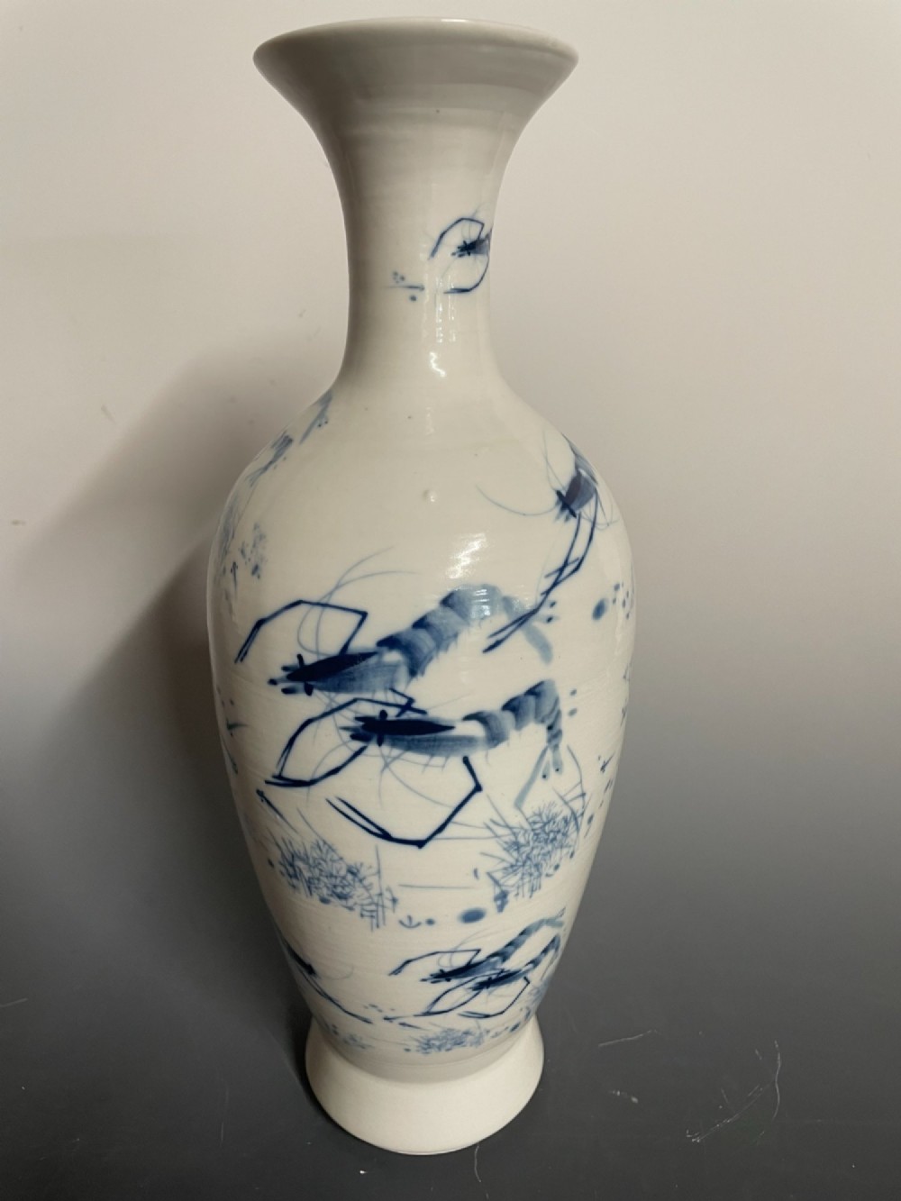A tall white porcelain vase with a flared rim, featuring hand-painted cobalt blue shrimp motifs around the body. View IV
