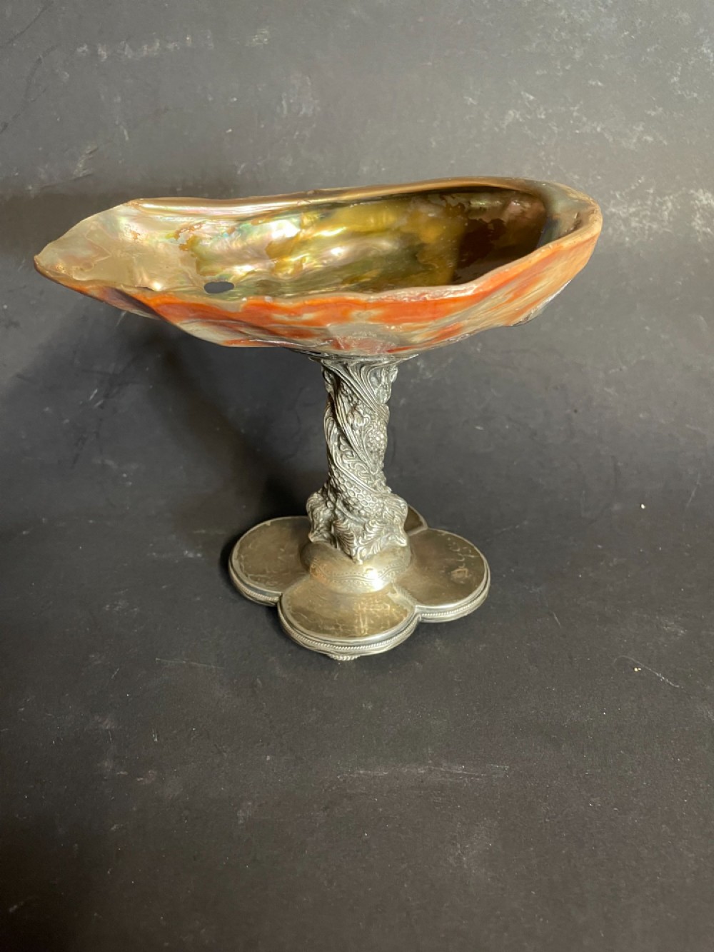 An antique abalone shell dish mounted on a relief-carved silvered metal pedestal with a lobed base. View III