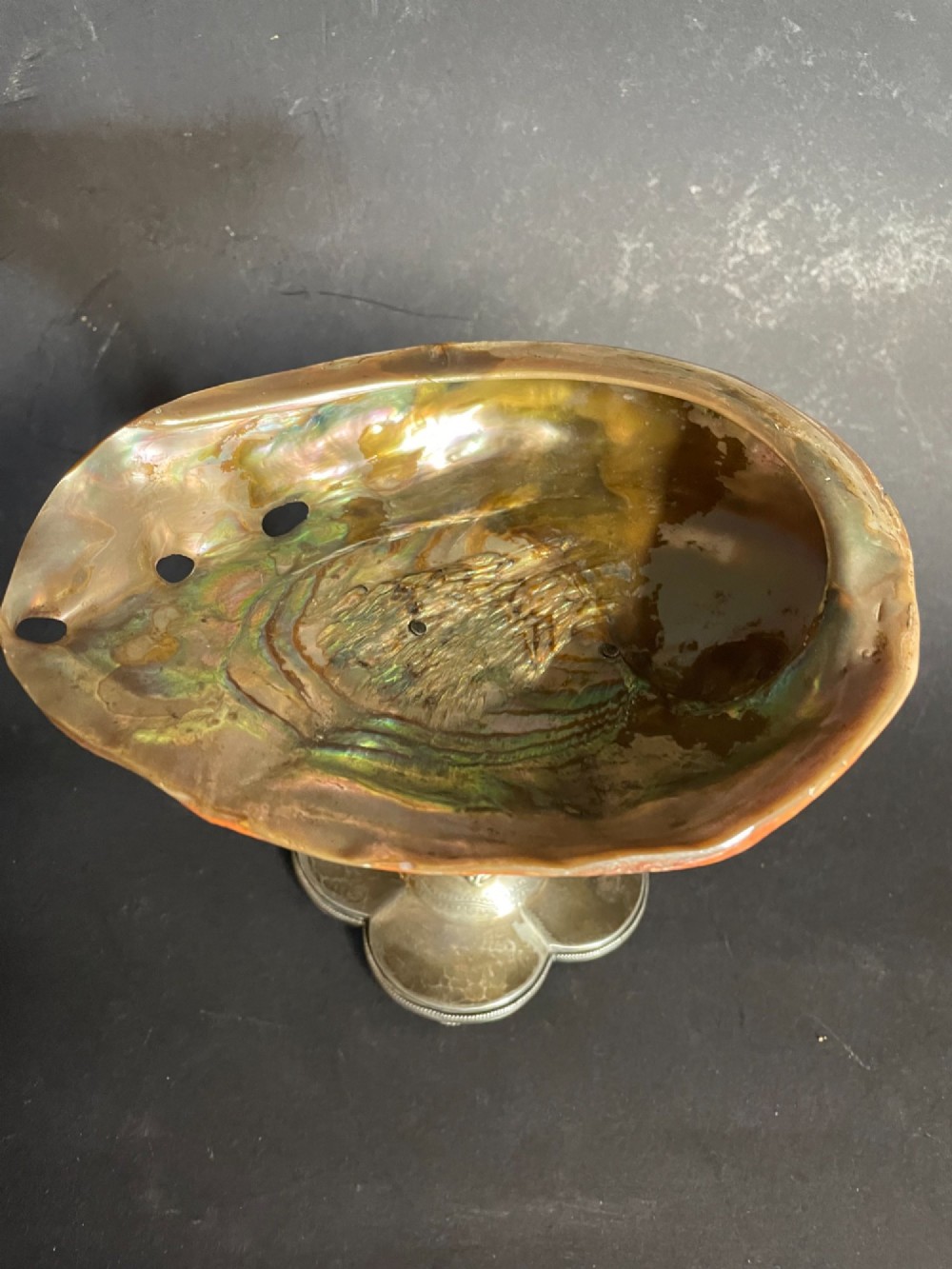 An antique abalone shell dish mounted on a relief-carved silvered metal pedestal with a lobed base. View IV