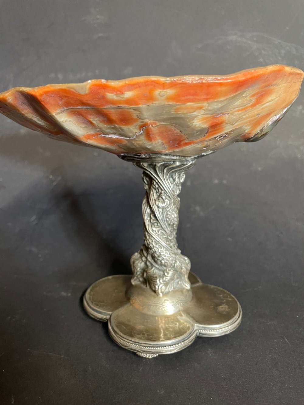 An antique abalone shell dish mounted on a relief-carved silvered metal pedestal with a lobed base. View V