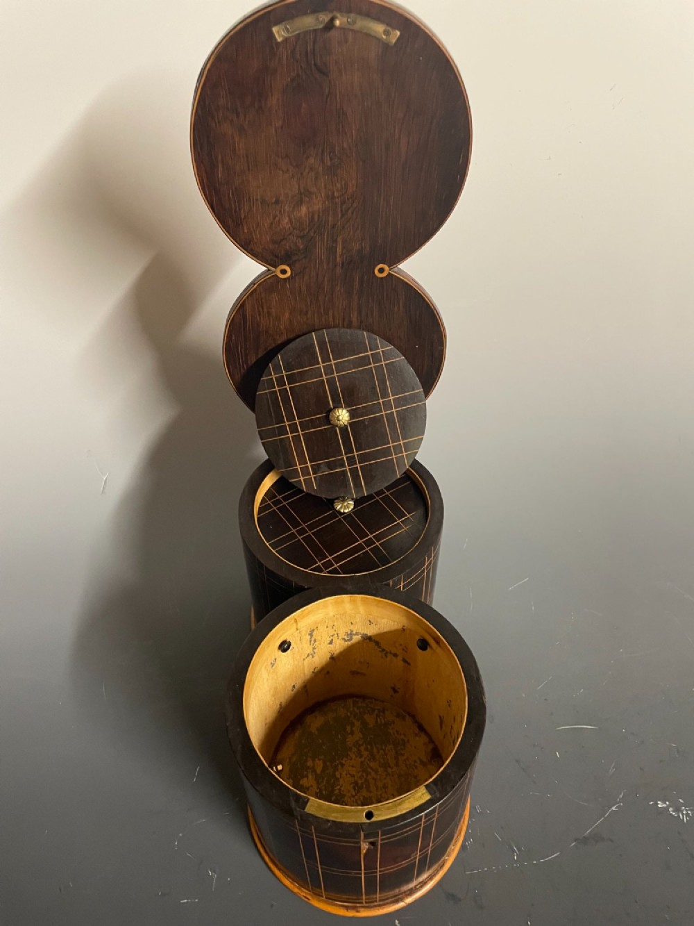 A dark brown wooden double cylindrical tea caddy featuring geometric line inlay and detailed figural marquetry scenes on the lids. View VII