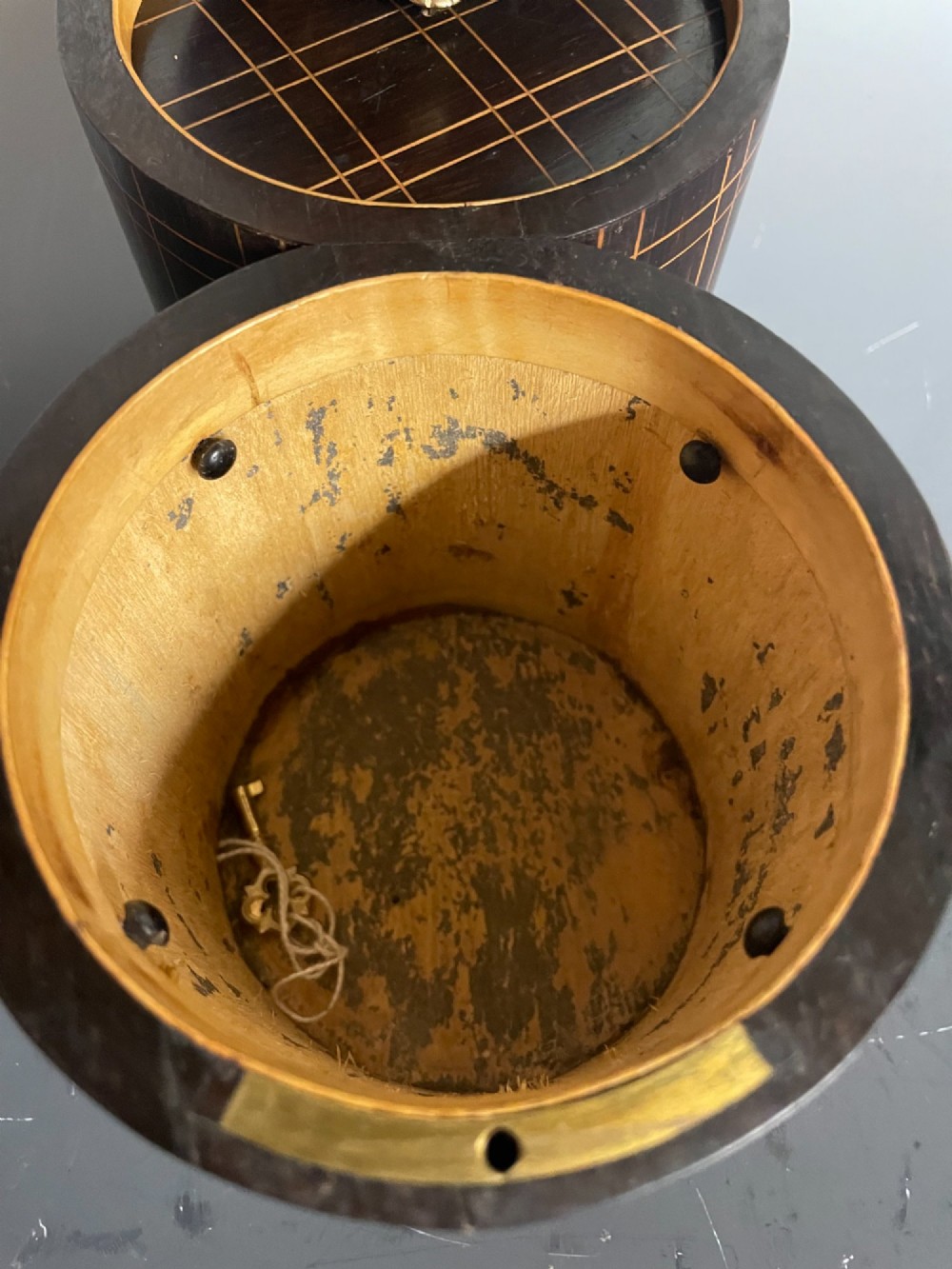 A dark brown wooden double cylindrical tea caddy featuring geometric line inlay and detailed figural marquetry scenes on the lids. View VIII