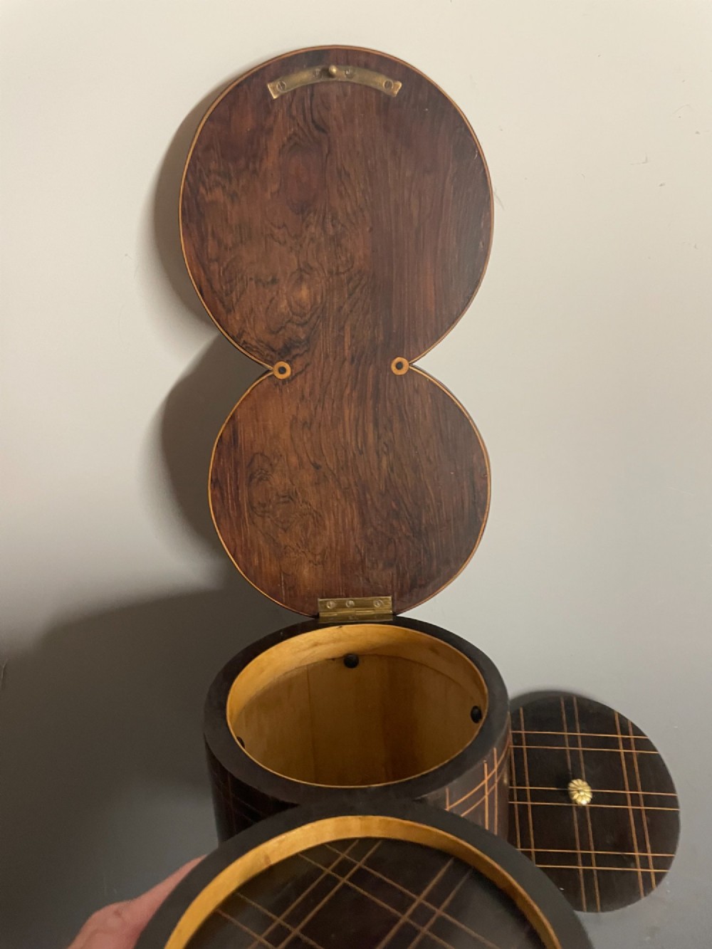 A dark brown wooden double cylindrical tea caddy featuring geometric line inlay and detailed figural marquetry scenes on the lids. View X