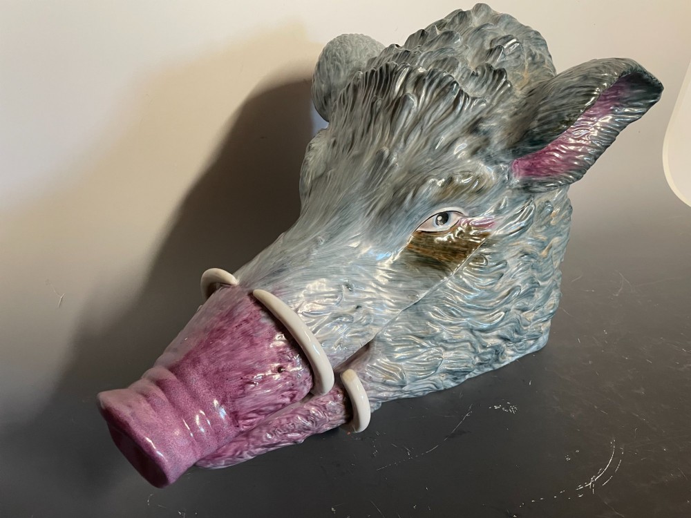 A glazed ceramic majolica tureen sculpted in the shape of a boars head with grey textured fur, pink snout, and white tusks. View II
