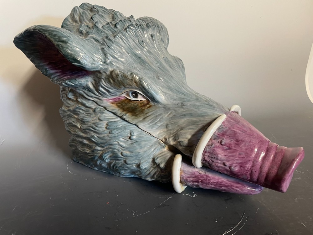 A glazed ceramic majolica tureen sculpted in the shape of a boars head with grey textured fur, pink snout, and white tusks. View IV
