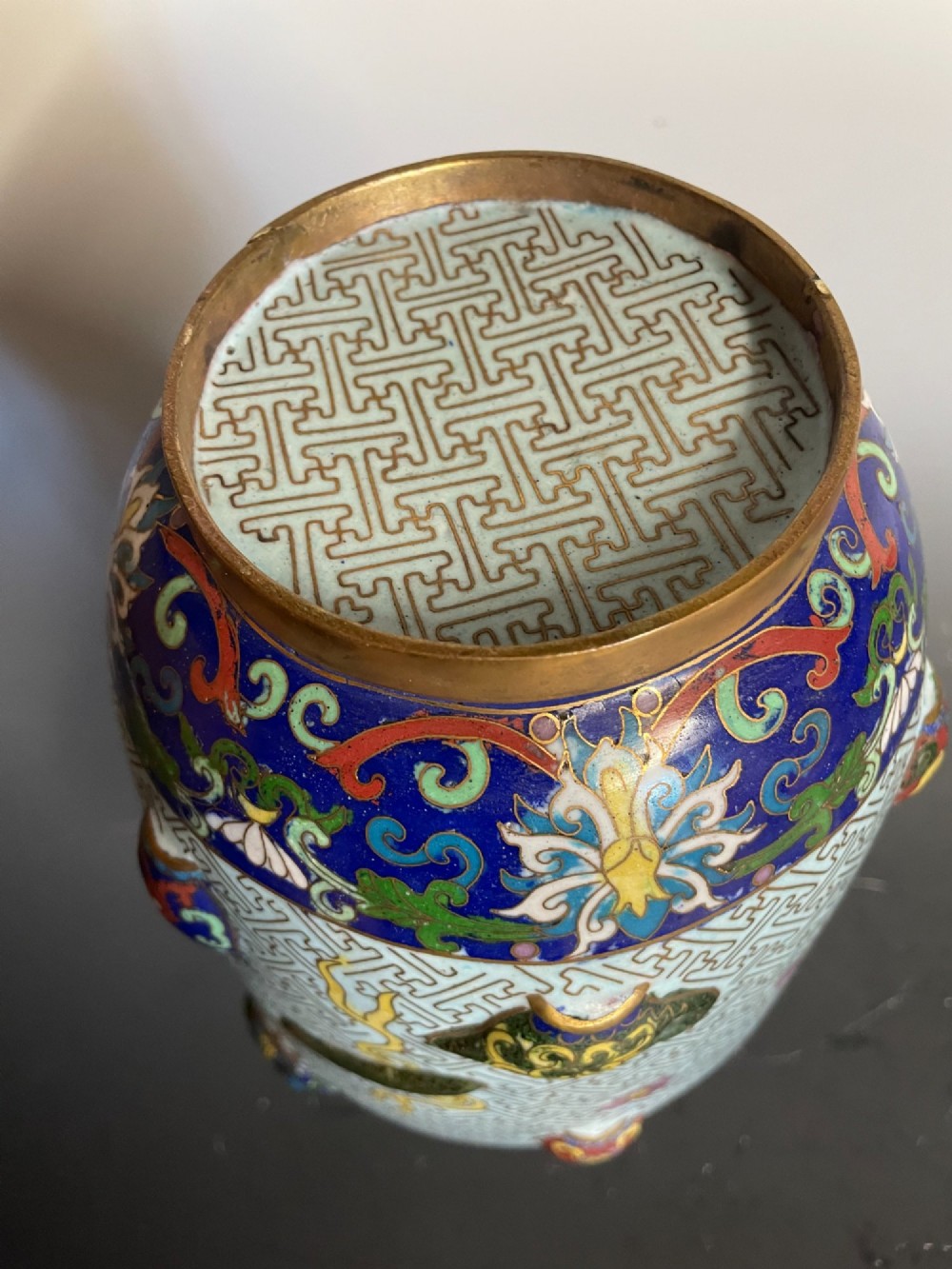 A baluster-shaped Chinese cloisonne enamel vase featuring a light blue key fret background embellished with colourful scholars objects and floral motifs. View VI