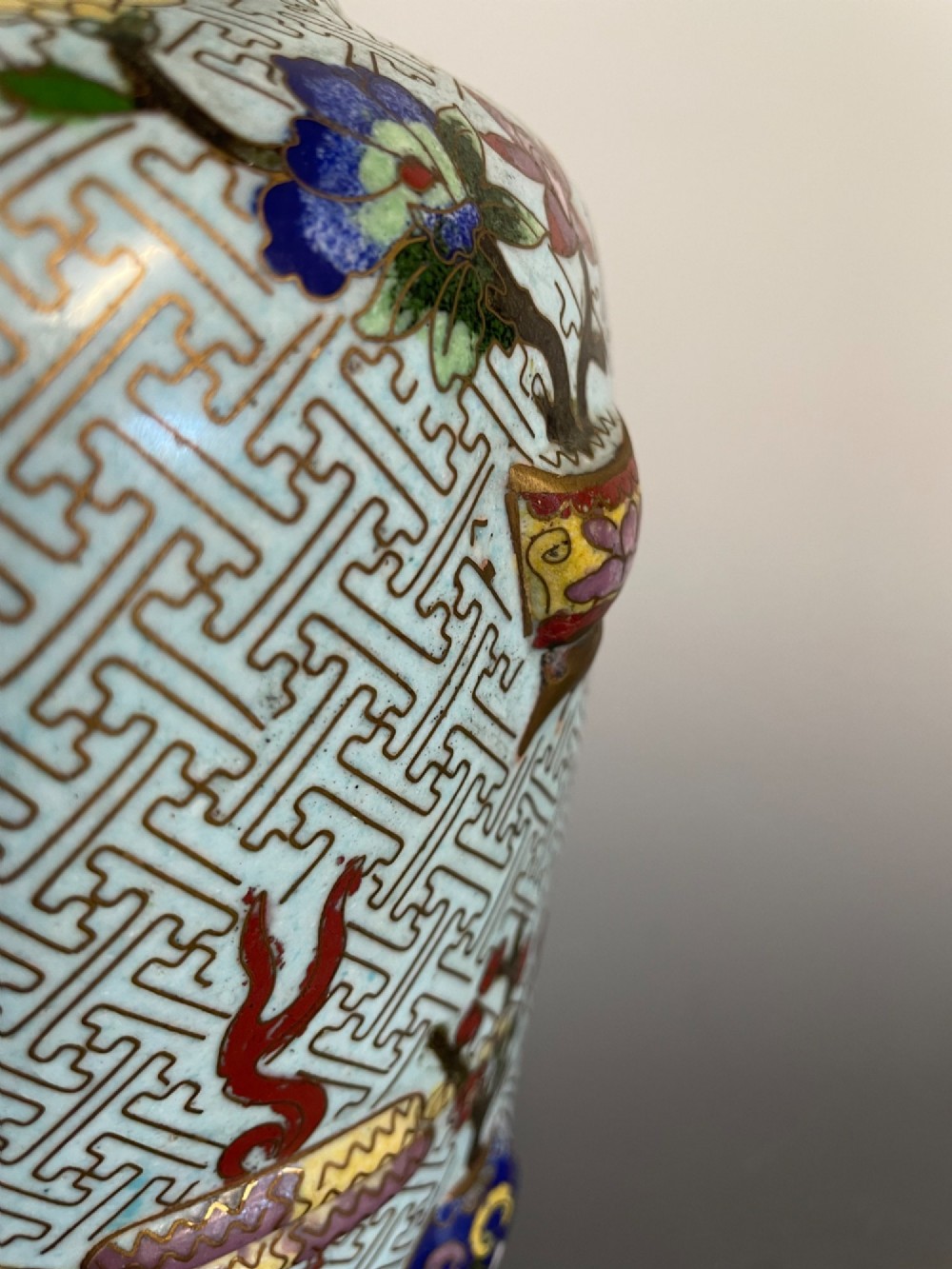 A baluster-shaped Chinese cloisonne enamel vase featuring a light blue key fret background embellished with colourful scholars objects and floral motifs. View VII