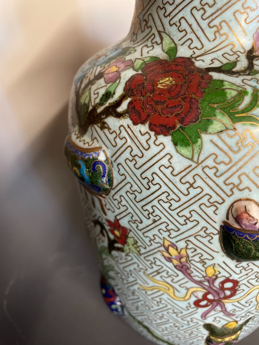A baluster-shaped Chinese cloisonne enamel vase featuring a light blue key fret background embellished with colourful scholars objects and floral motifs. View VIII