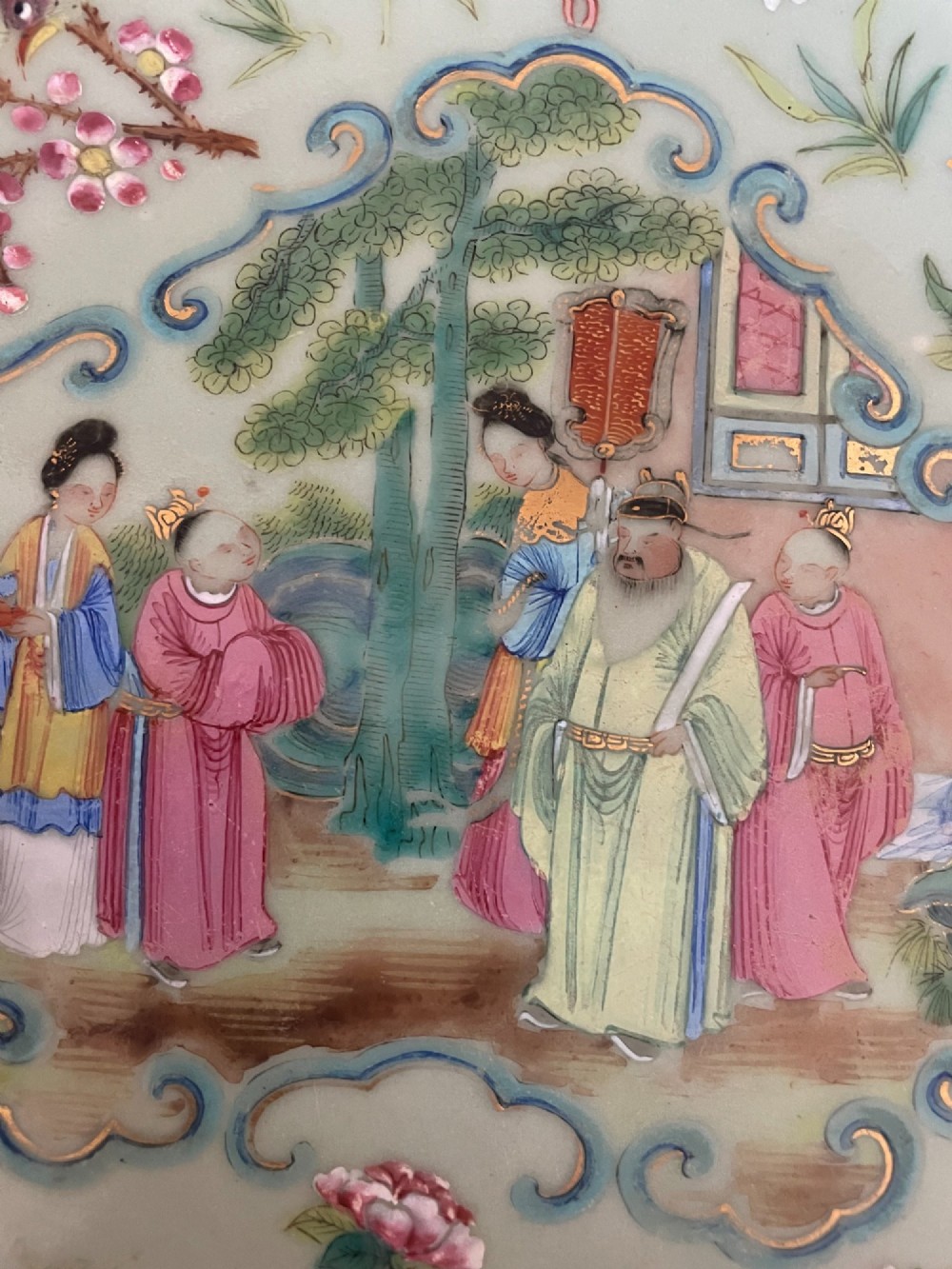A circular Chinese export celadon porcelain plate hand-painted with a central figurative reserve surrounded by floral motifs, birds, and butterflies in multi-coloured enamels. View II