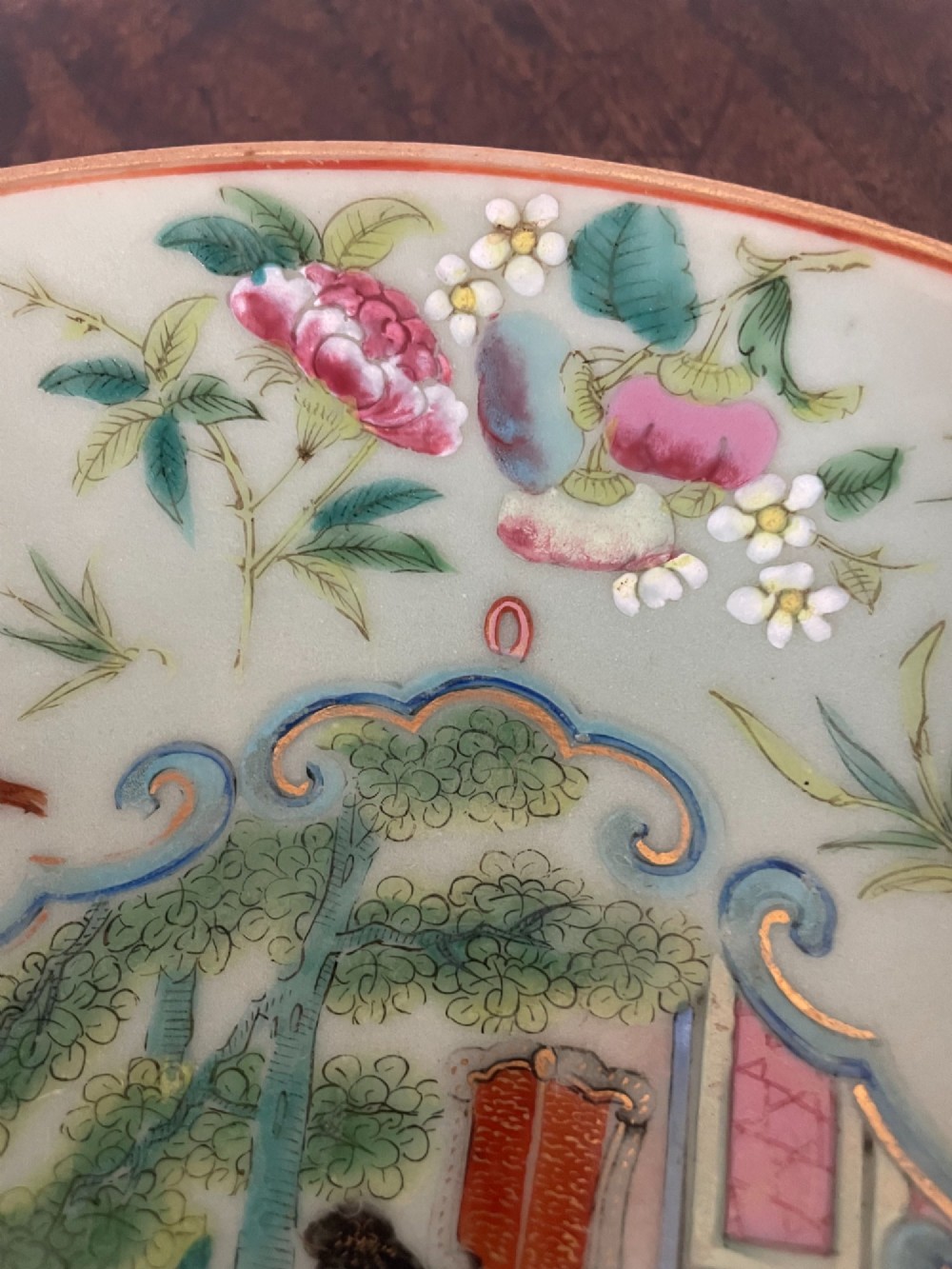 A circular Chinese export celadon porcelain plate hand-painted with a central figurative reserve surrounded by floral motifs, birds, and butterflies in multi-coloured enamels. View VI
