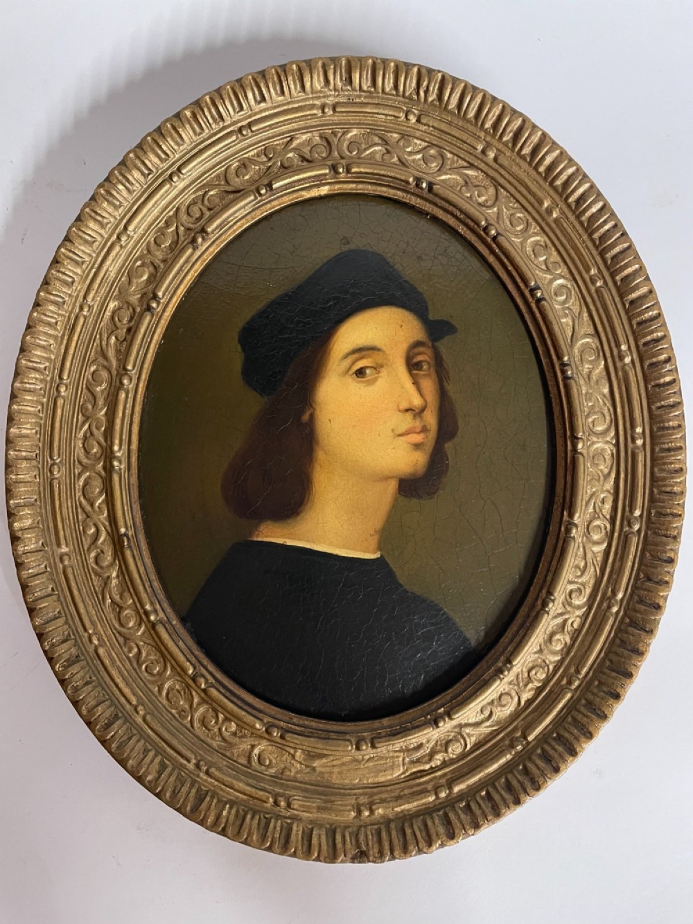 Set of three oval portrait paintings featuring Renaissance men housed within ornate carved giltwood frames. View II