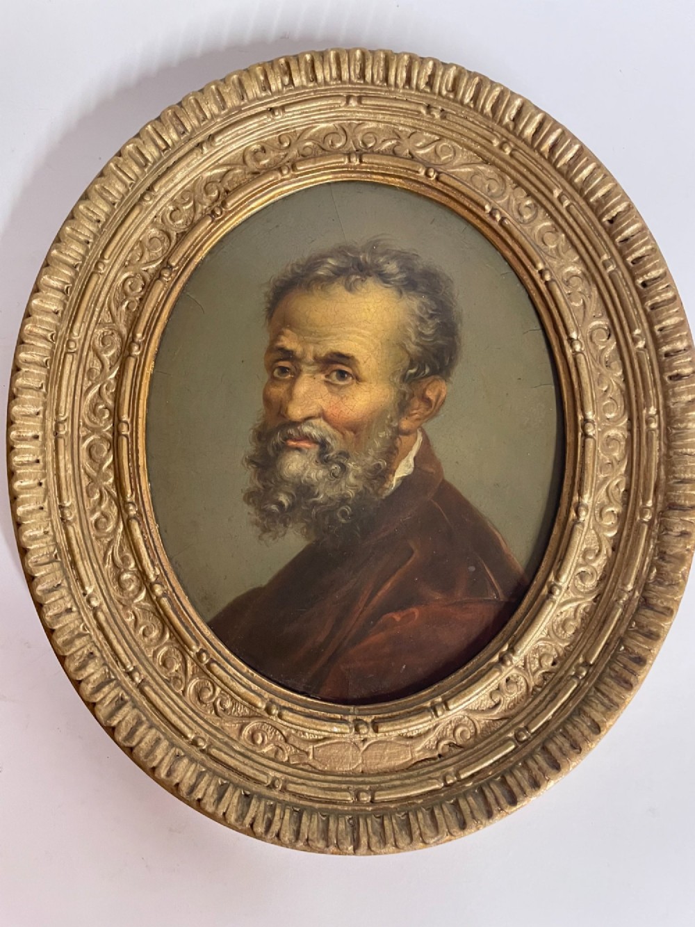 Set of three oval portrait paintings featuring Renaissance men housed within ornate carved giltwood frames. View IV