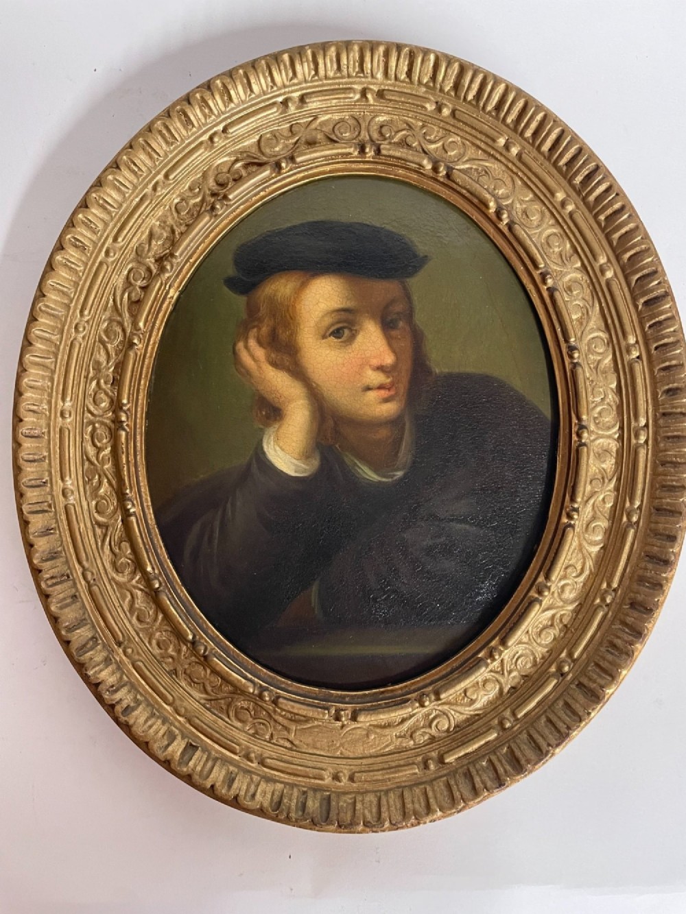 Set of three oval portrait paintings featuring Renaissance men housed within ornate carved giltwood frames. View VI