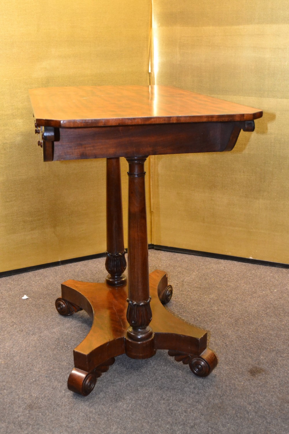 A William IV mahogany side table featuring carved scroll brackets, twin turned column supports, and a shaped plinth base on scroll feet. View VI