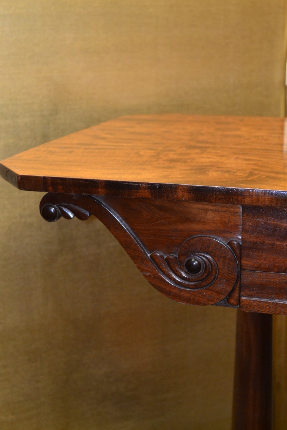 A William IV mahogany side table featuring carved scroll brackets, twin turned column supports, and a shaped plinth base on scroll feet. View IX