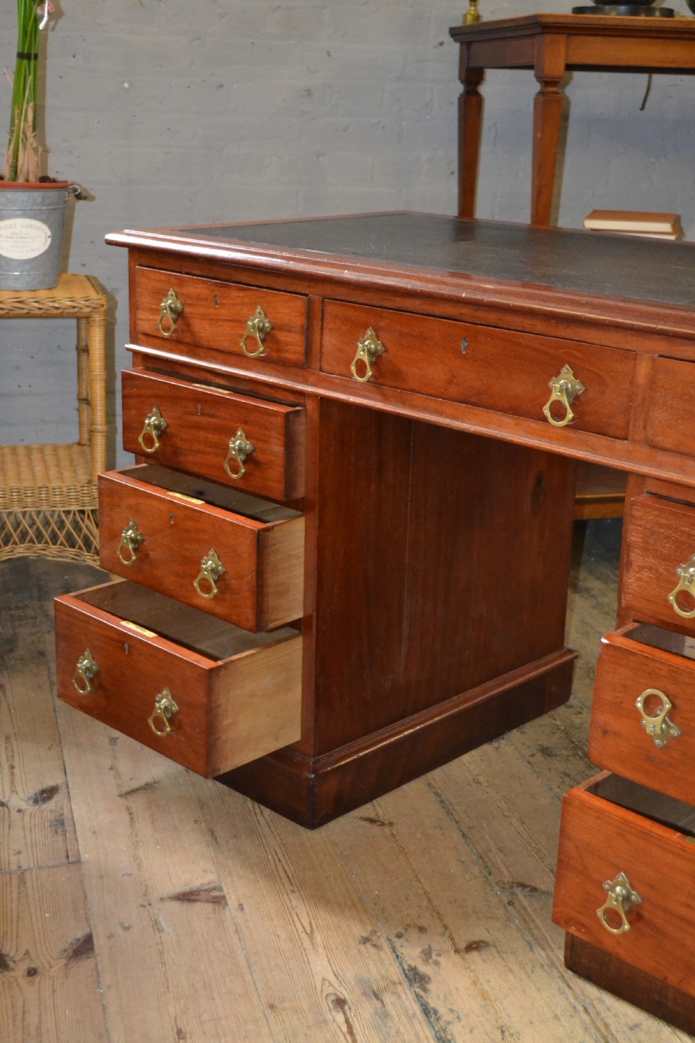 A Victorian walnut pedestal desk featuring nine drawers with brass handles and a dark leather writing insert. View II