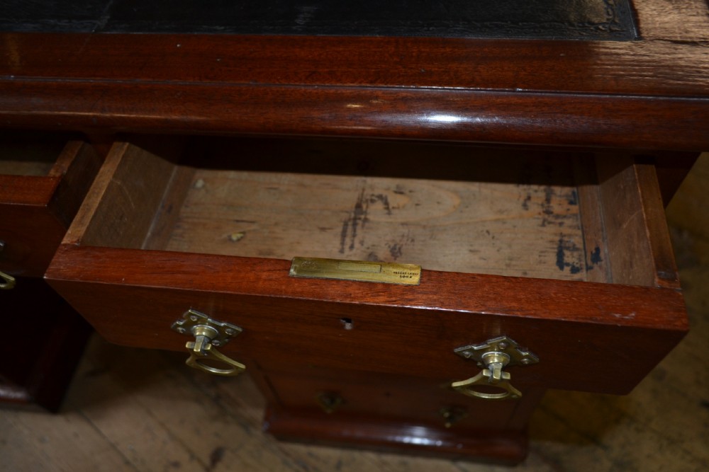 A Victorian walnut pedestal desk featuring nine drawers with brass handles and a dark leather writing insert. View III