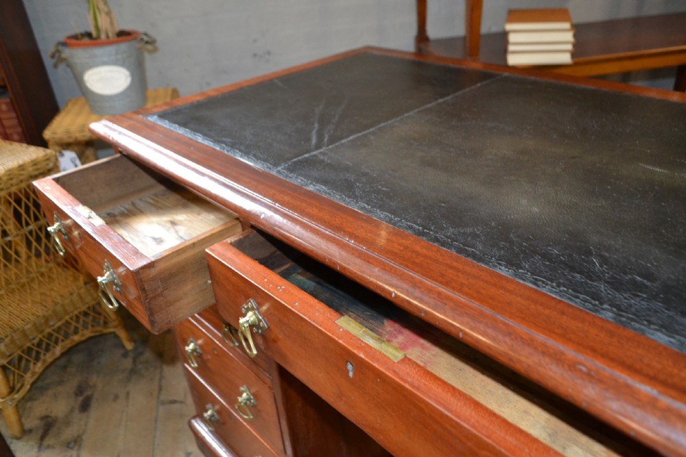 A Victorian walnut pedestal desk featuring nine drawers with brass handles and a dark leather writing insert. View IV