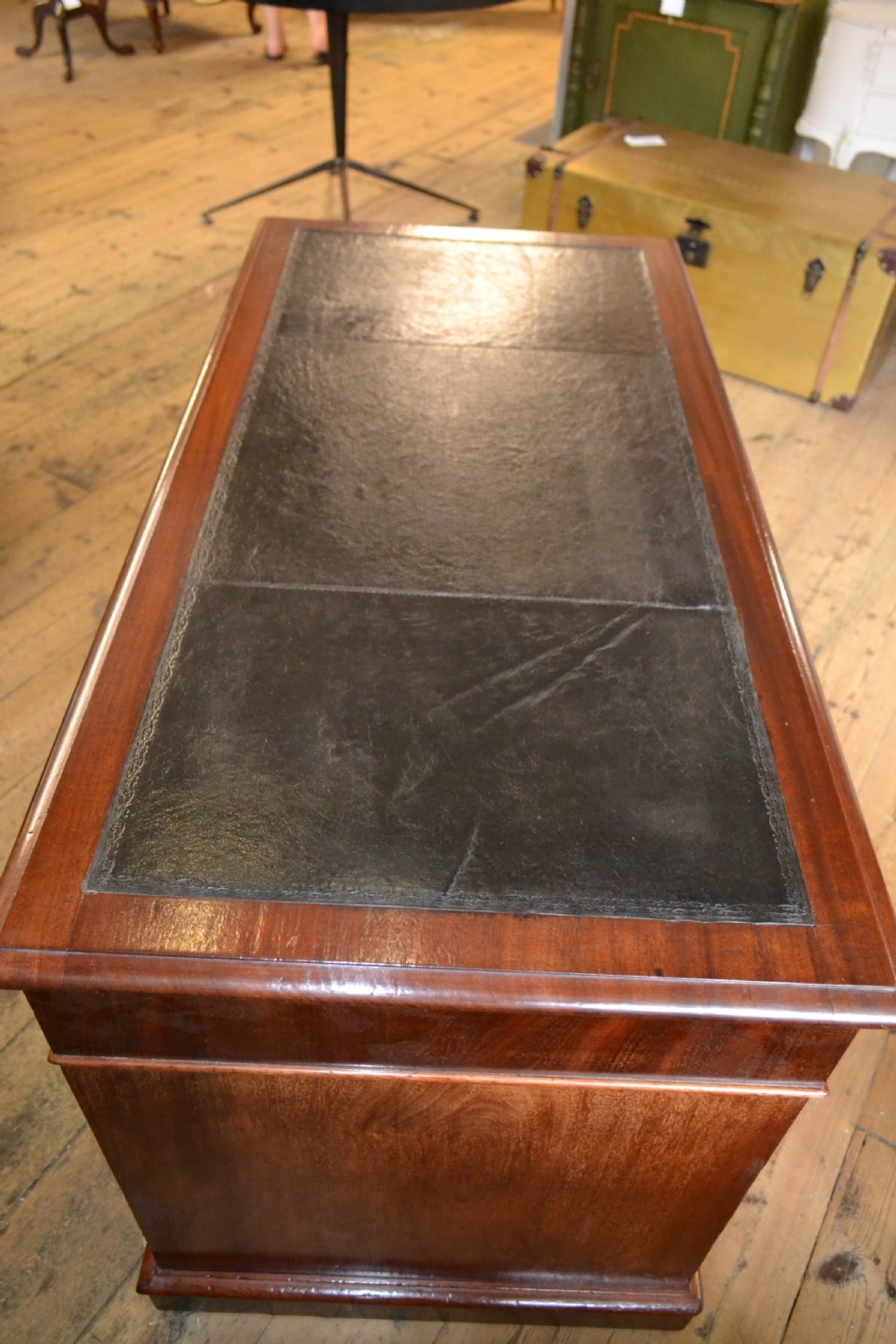 A Victorian walnut pedestal desk featuring nine drawers with brass handles and a dark leather writing insert. View V