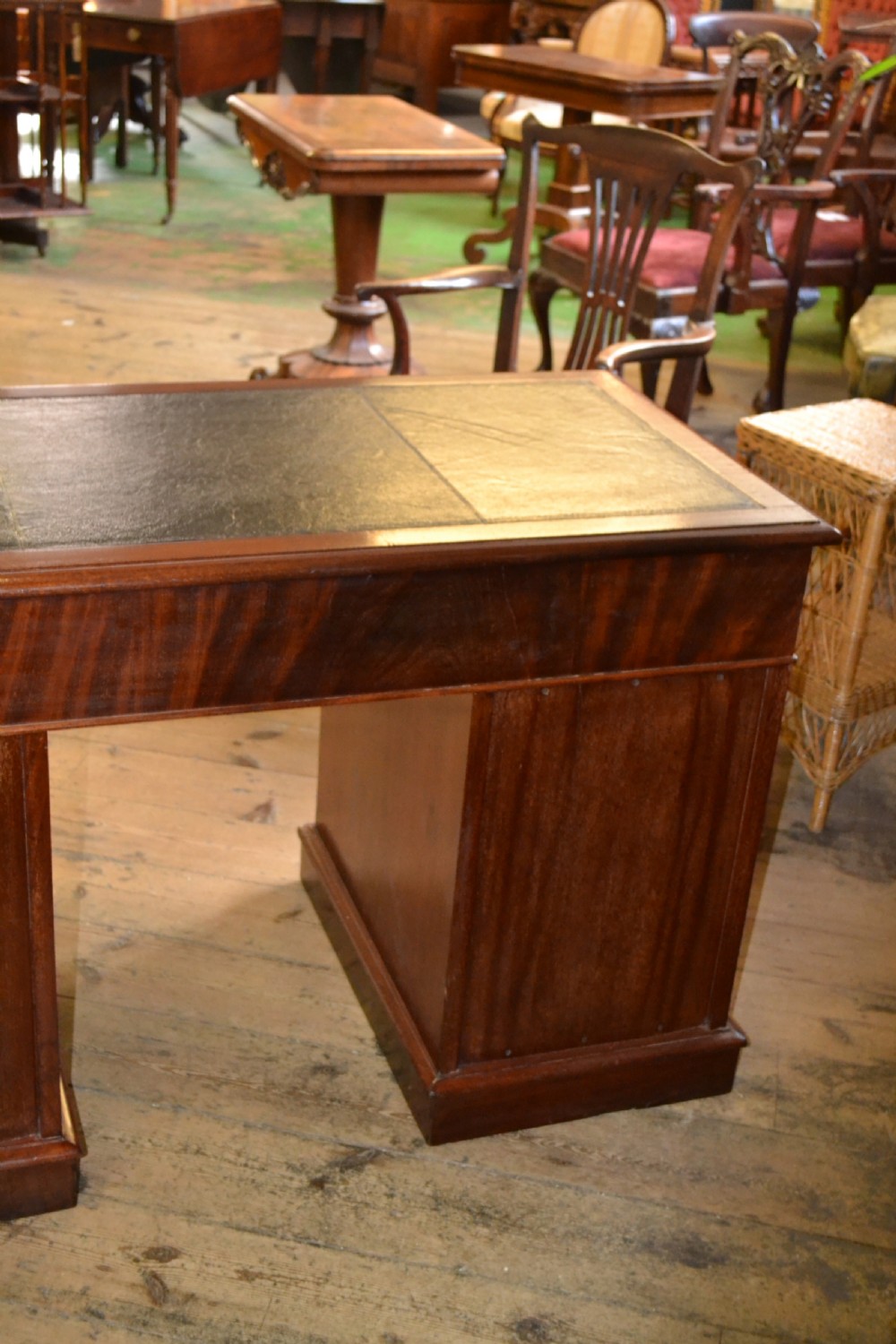 A Victorian walnut pedestal desk featuring nine drawers with brass handles and a dark leather writing insert. View VI