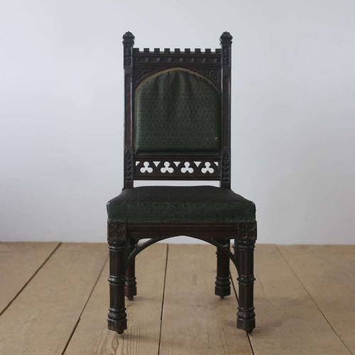 A pair of 19th-century Gothic Revival side chairs crafted from dark carved wood with dark green upholstered seats and backrests featuring pointed arch motifs. View II