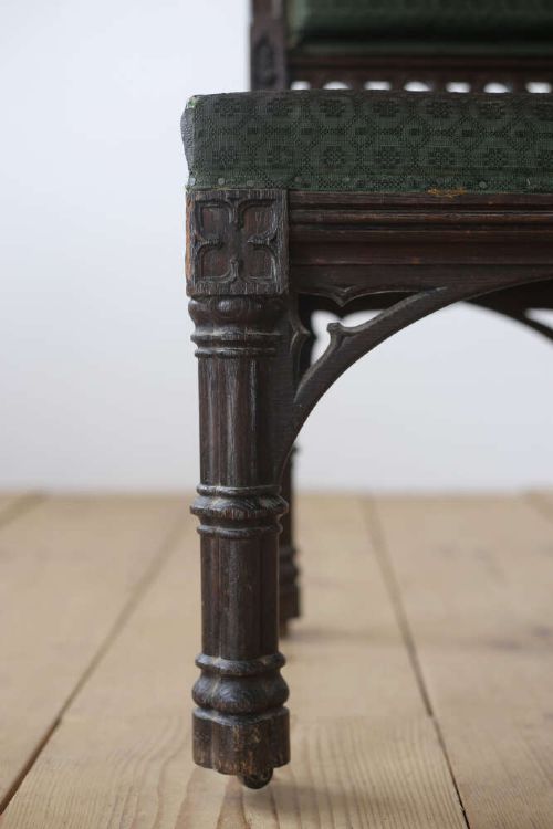 A pair of 19th-century Gothic Revival side chairs crafted from dark carved wood with dark green upholstered seats and backrests featuring pointed arch motifs. View III