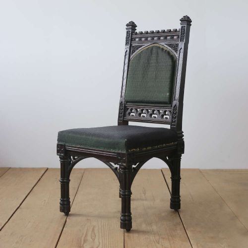 A pair of 19th-century Gothic Revival side chairs crafted from dark carved wood with dark green upholstered seats and backrests featuring pointed arch motifs. View IV