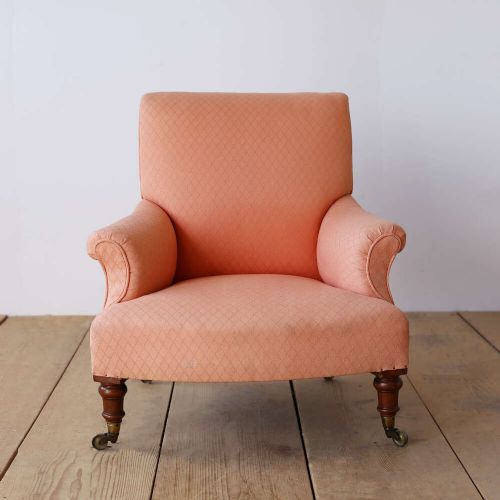 A pair of 19th-century upholstered armchairs in peach woven fabric featuring turned mahogany front legs with brass castors. View II