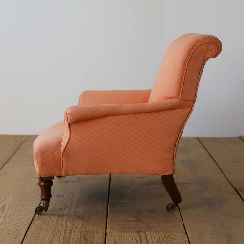 A pair of 19th-century upholstered armchairs in peach woven fabric featuring turned mahogany front legs with brass castors. View IV