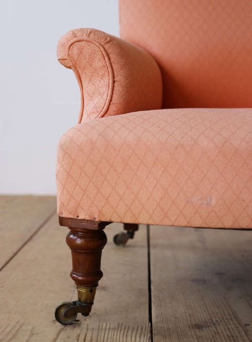 A pair of 19th-century upholstered armchairs in peach woven fabric featuring turned mahogany front legs with brass castors. View VI