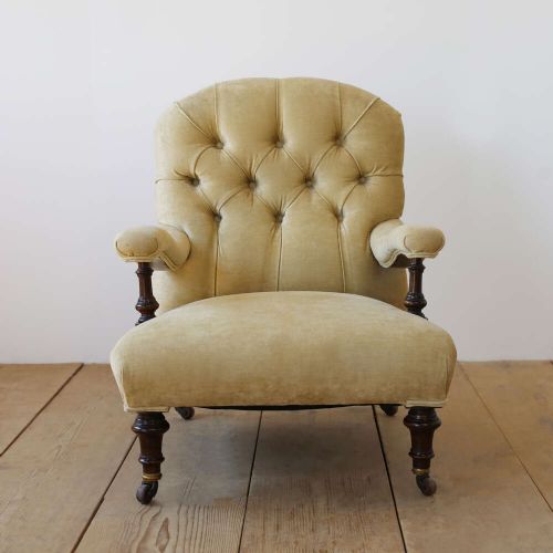 A 19th-century Victorian button-backed open armchair featuring sage green upholstery, turned dark mahogany front legs, and brass castors. View II