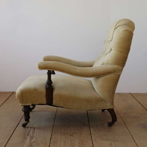A 19th-century Victorian button-backed open armchair featuring sage green upholstery, turned dark mahogany front legs, and brass castors. View III
