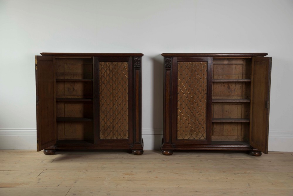 A pair of matching dark mahogany low cabinets featuring double doors with brass diamond wire grilles and carved corner accents. View II