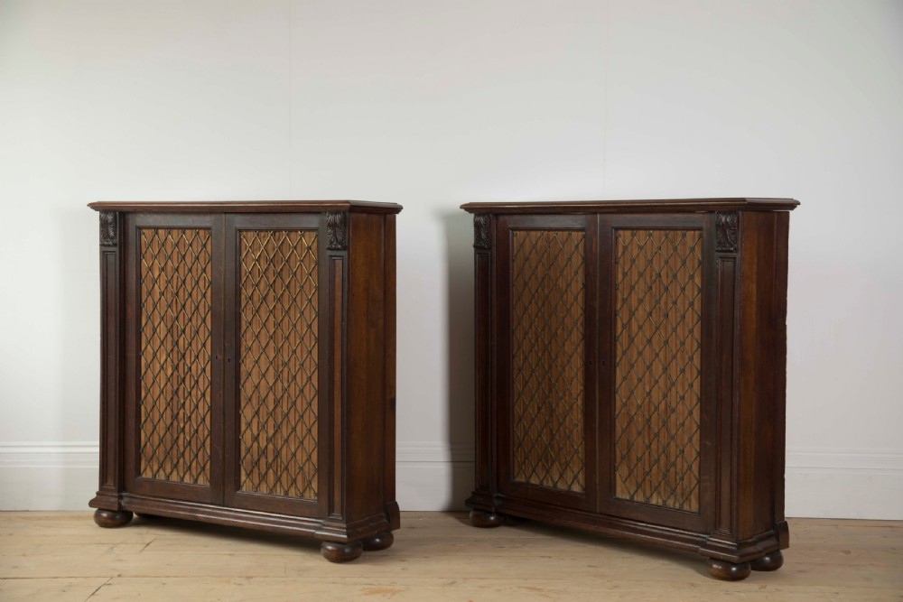 A pair of matching dark mahogany low cabinets featuring double doors with brass diamond wire grilles and carved corner accents. View III