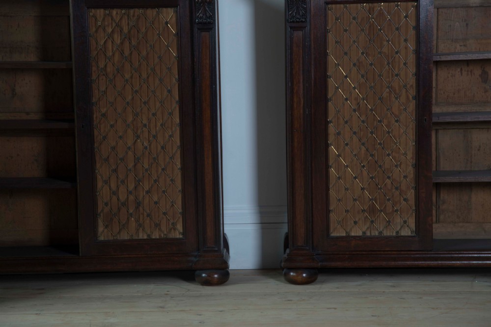 A pair of matching dark mahogany low cabinets featuring double doors with brass diamond wire grilles and carved corner accents. View IV