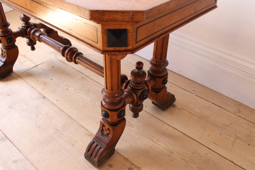 A 19th-century rectangular warm brown walnut centre table featuring inlaid apron details, twin fluted column supports, and a central turned stretcher. View IV