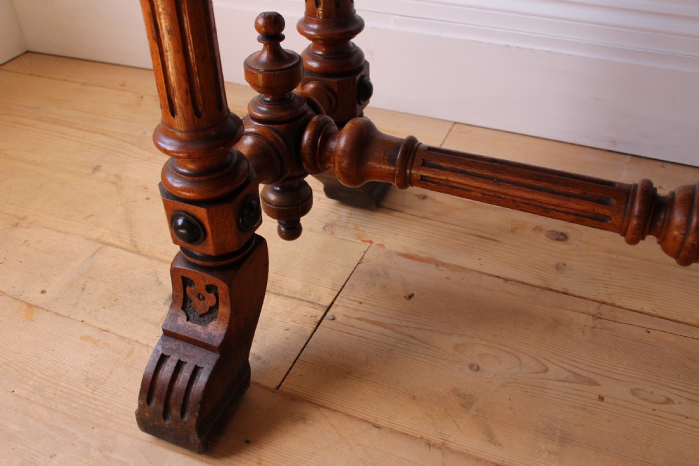 A 19th-century rectangular warm brown walnut centre table featuring inlaid apron details, twin fluted column supports, and a central turned stretcher. View V