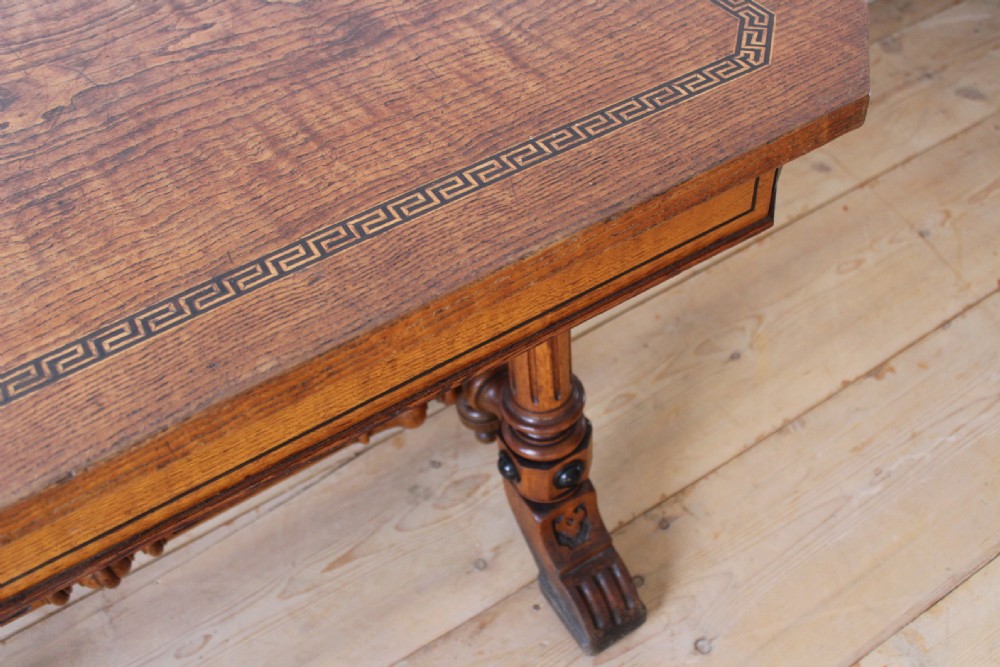 A 19th-century rectangular warm brown walnut centre table featuring inlaid apron details, twin fluted column supports, and a central turned stretcher. View VI