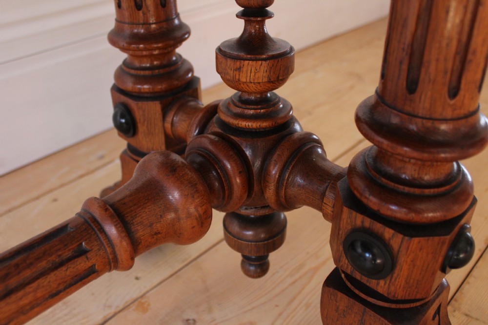 A 19th-century rectangular warm brown walnut centre table featuring inlaid apron details, twin fluted column supports, and a central turned stretcher. View VIII