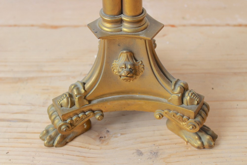 A nineteenth-century cast brass column table lamp featuring a clustered shaft, decorative foliate mounts, and a tri-form base resting on paw feet. View VI