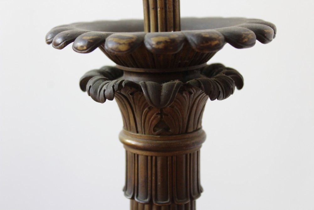 A pair of antique dark patinated bronze French Empire table lamps featuring fluted columns, acanthus leaf details, and stepped bases. View IV