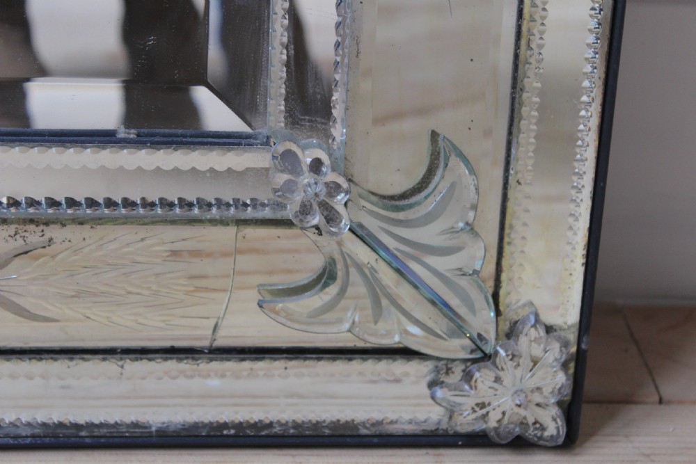 A nineteenth-century Venetian glass wall mirror featuring etched floral motifs, glass rosette fasteners, and a decorative foliate crest. View IV