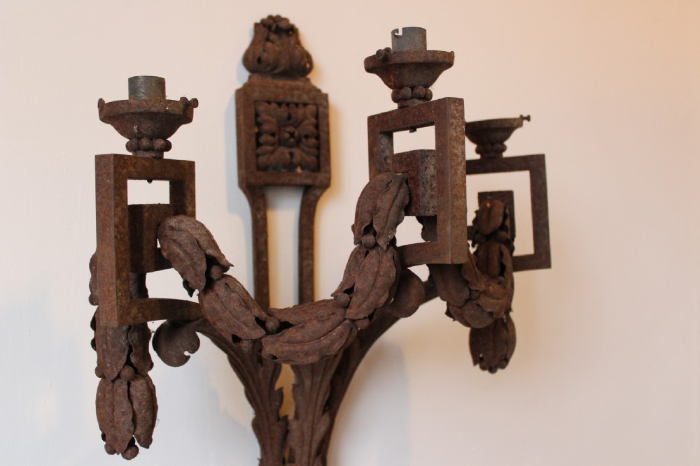 A 19th-century three-light wall sconce crafted from dark oxidised iron with carved acanthus leaves and hanging foliage swags. View V