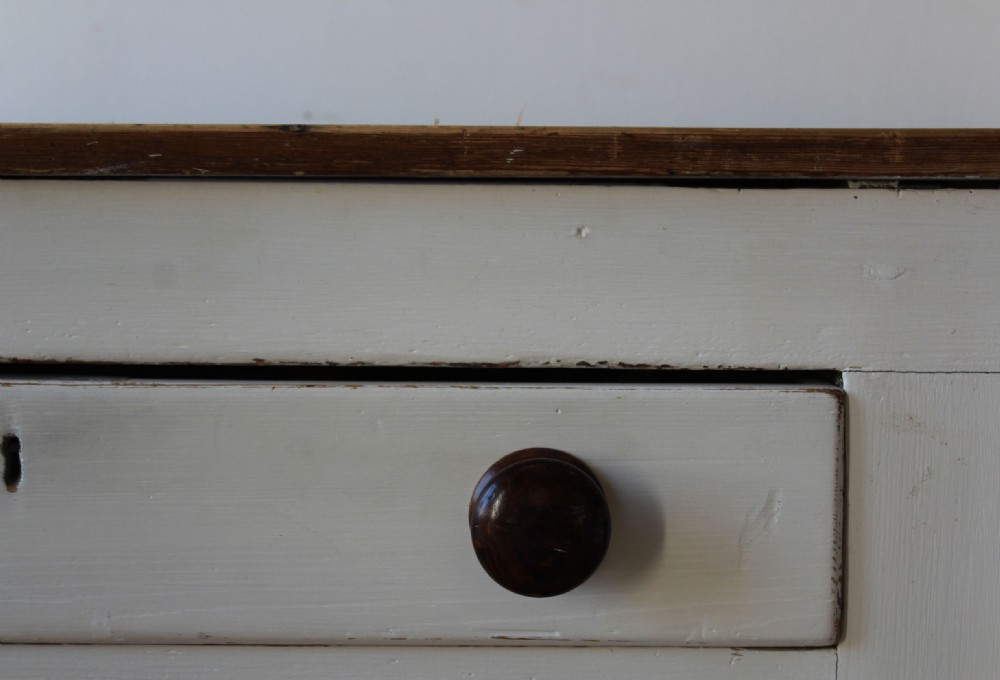 A wide 19th-century off-white painted wooden dresser base featuring four central drawers with dark wooden knobs, two double-panelled side doors, and a natural wood tabletop. View IV