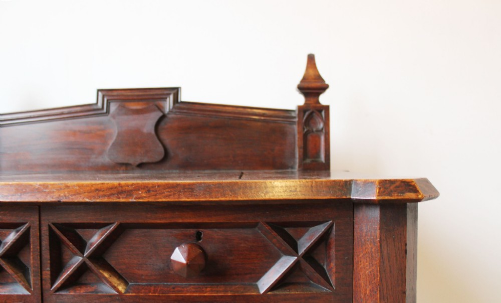 A 19th-century Gothic Revival dark wood hall table featuring a carved gallery backboard with finials, two drawers with geometric moulding, and turned legs. View III