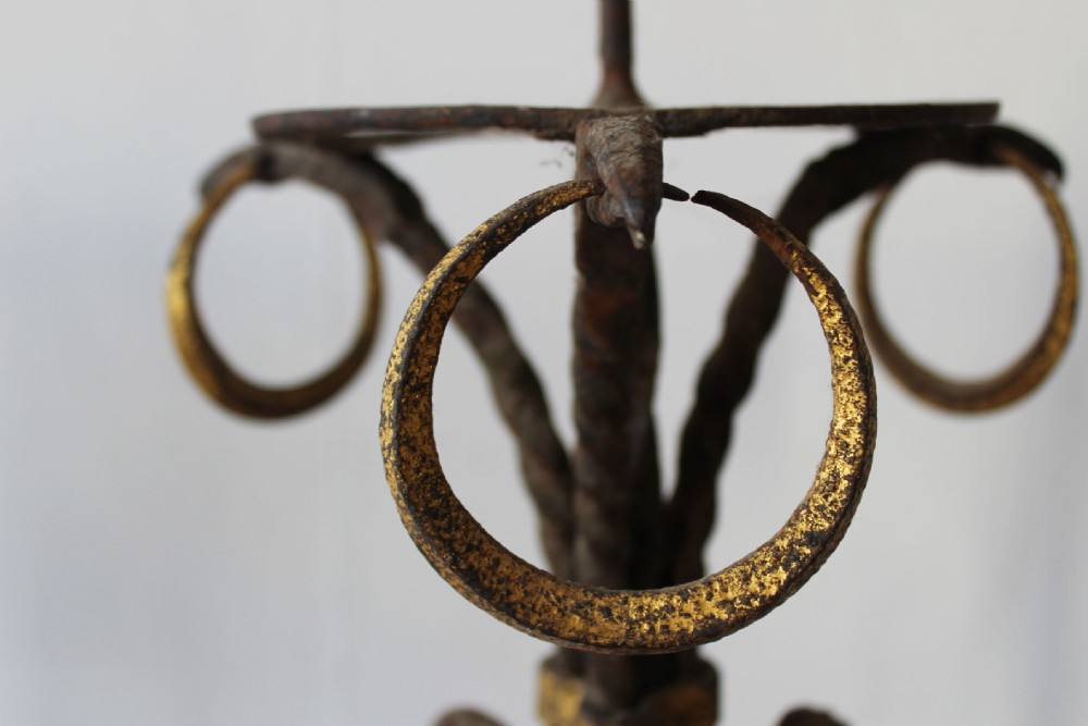 A pair of tall 19th-century wrought iron pricket candlesticks featuring twisted stems, scrolled tripod bases, and gilded highlights. View III