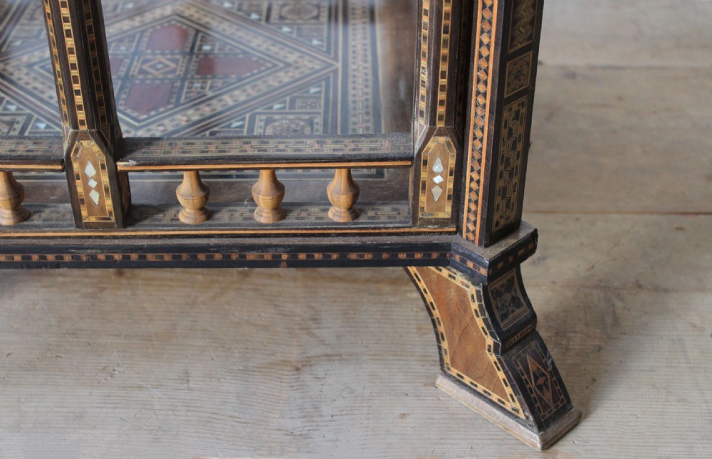 A 20th-century games table decorated with intricate geometric marquetry, mother-of-pearl inlay, and carved horseshoe arch aprons. View V